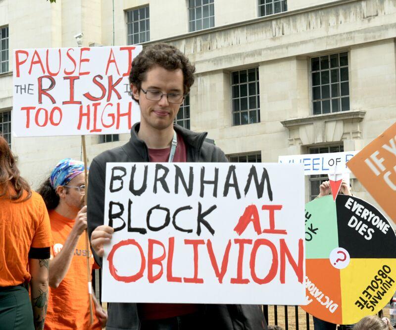 A protester holding a sign reading Burnham, block AI oblivion