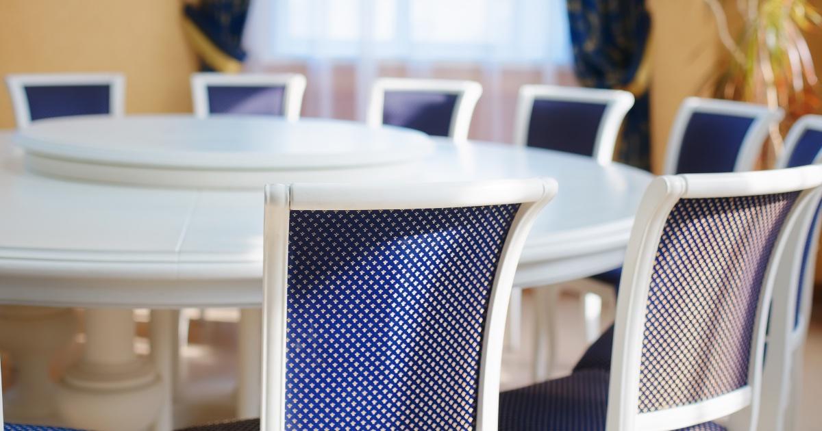 Empty chairs around a round white conference table