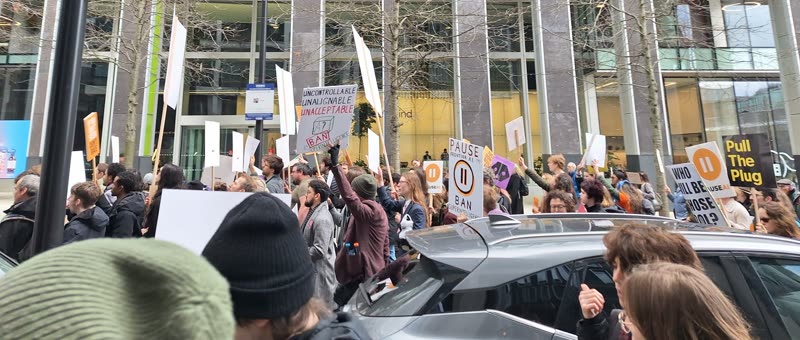 Marchers walking past DeepMind offices